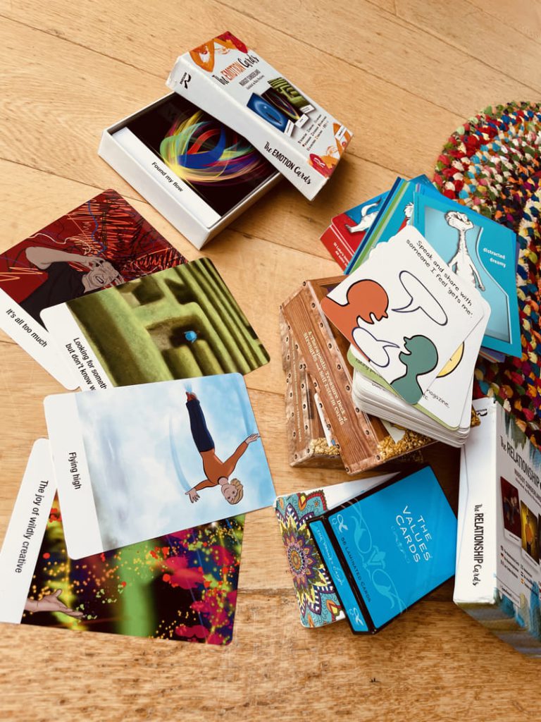 Therapeutic cards spread out on a hardwood floor.