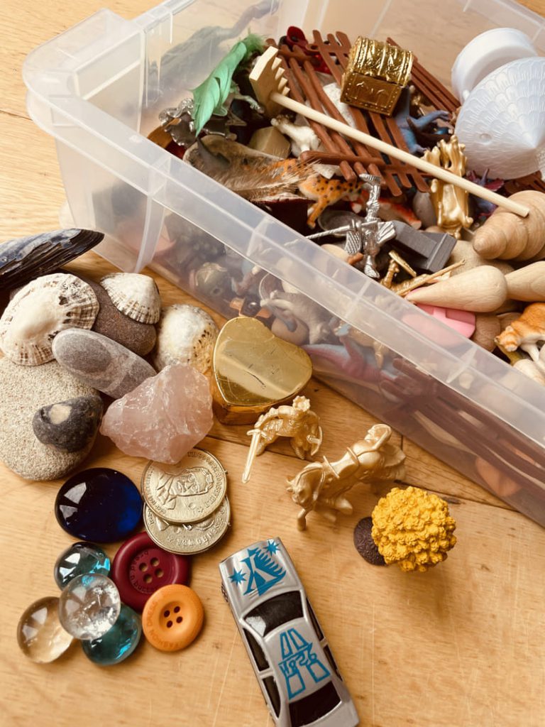 A sandbox containing a range of sensory materials and toys.